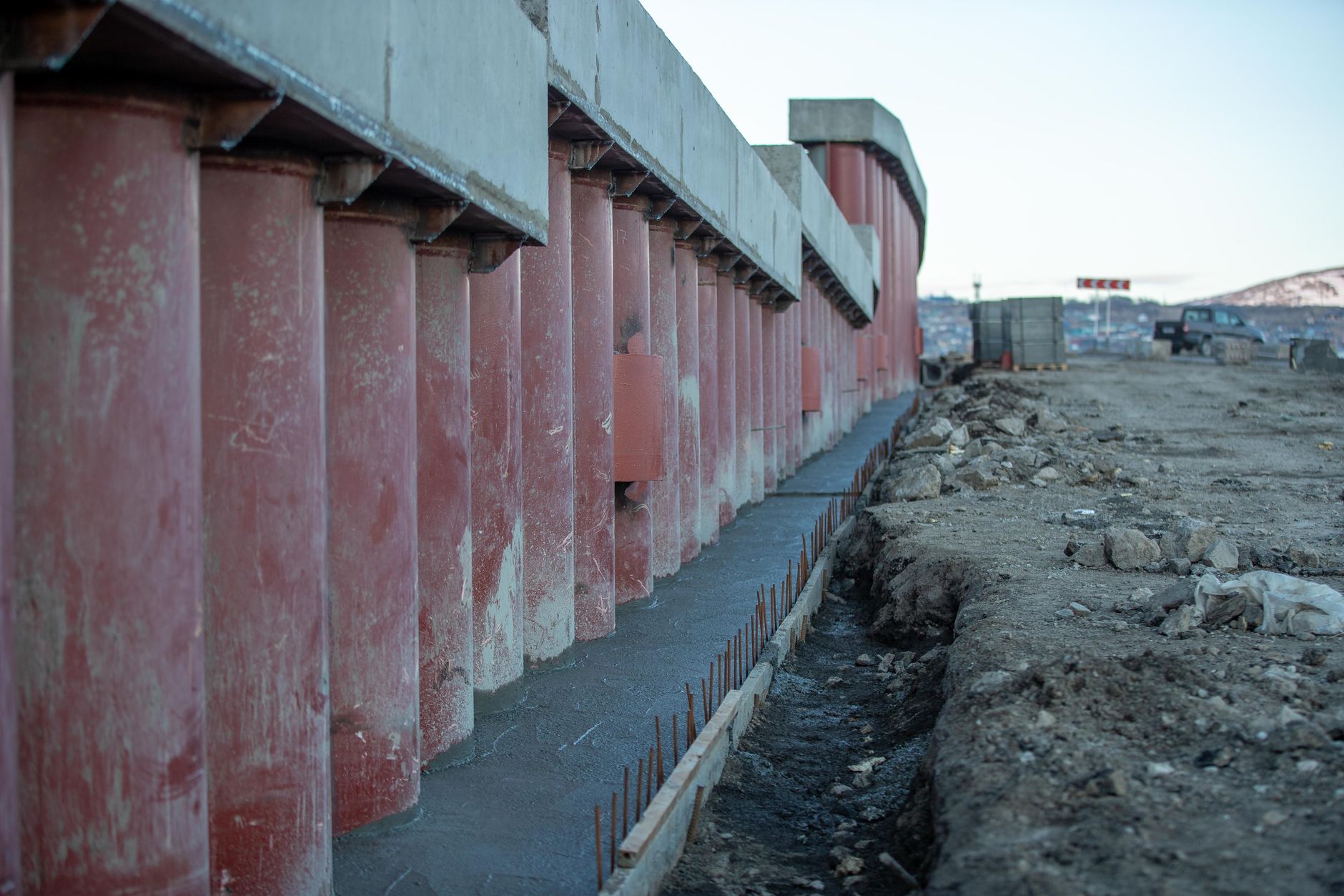Rohbau mit Betonsäulen und Baumaschinen auf der Baustelle