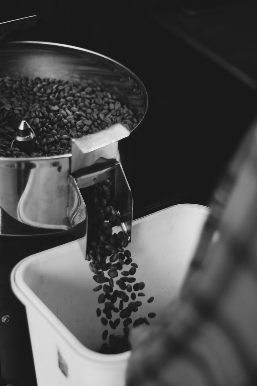Kaffeebohnen fallen beim Rösten aus der Trommel