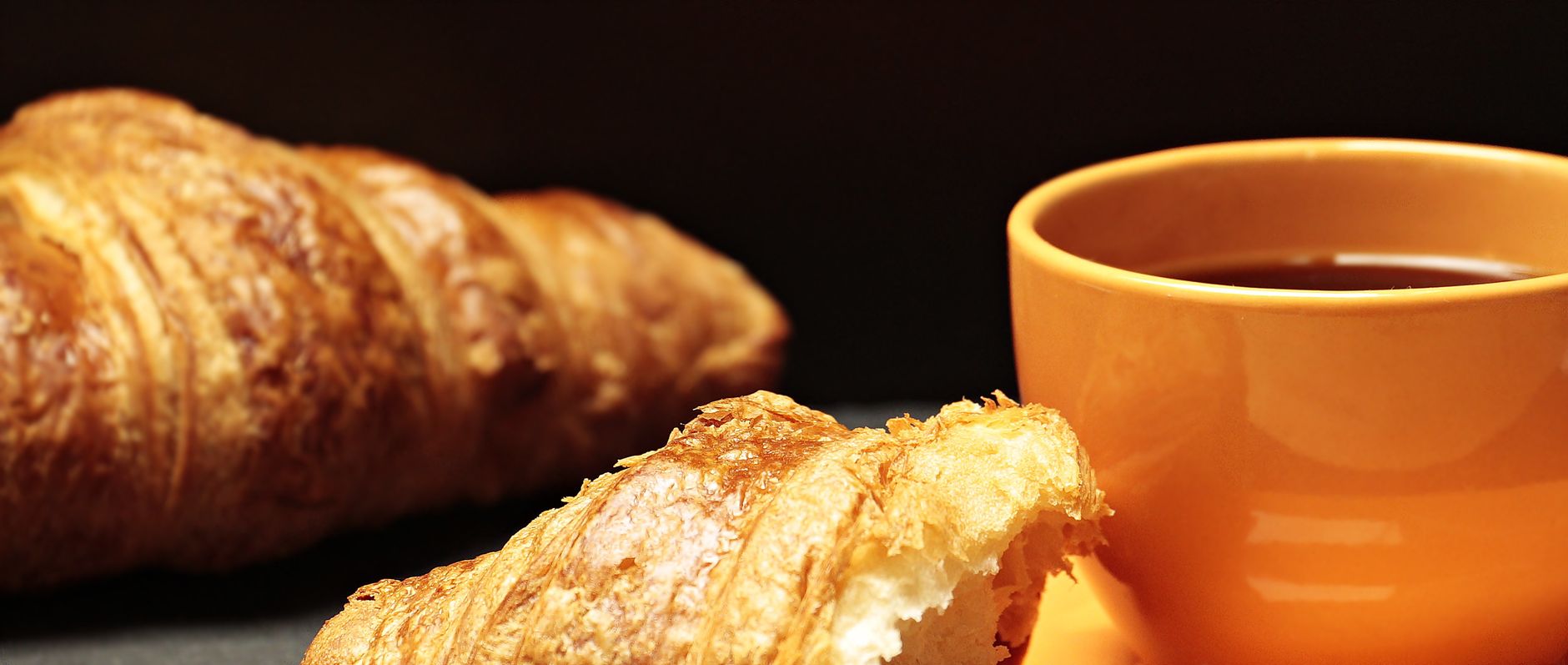 Frisches Croissant mit einer Tasse Kaffee zum Frühstück