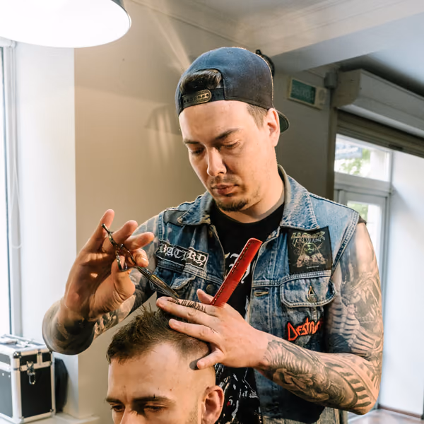Ein Barbier schneidet einem Kunden die Haare